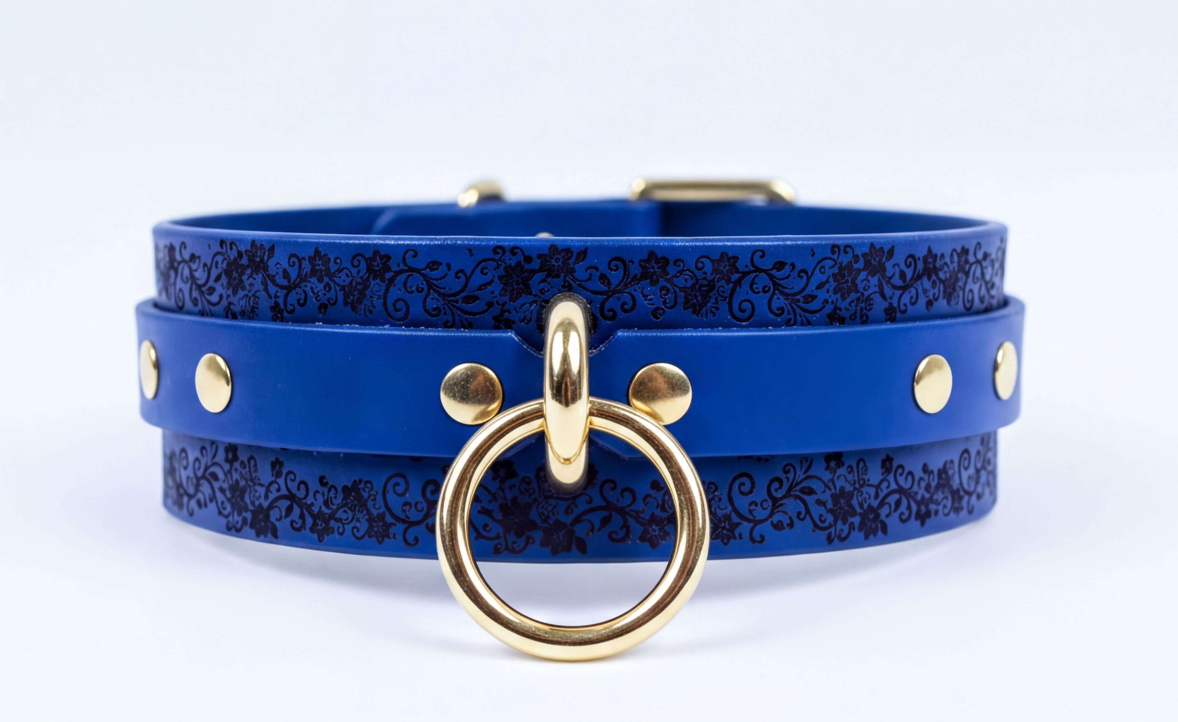 A blue leather choker necklace with a gold-colored metal ring and studs on the front.