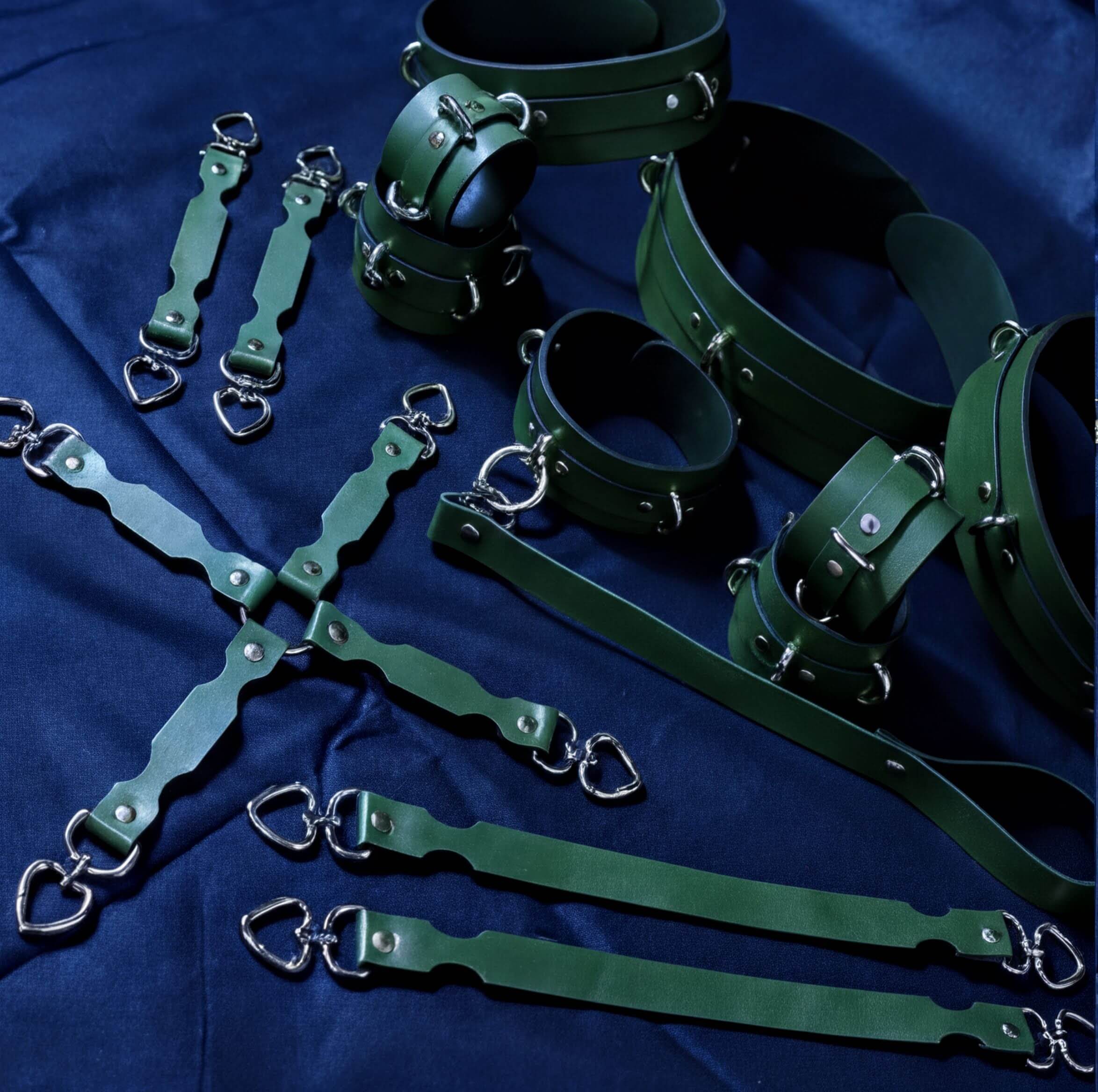 a collection of green leather straps and buckles arranged on a blue background.