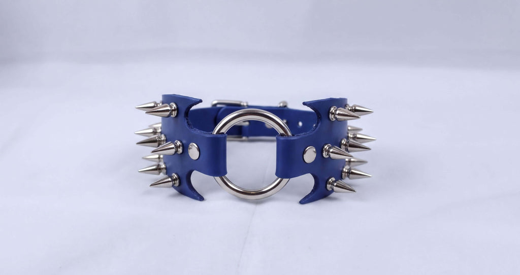 A blue leather bracelet with silver spikes protruding from it.