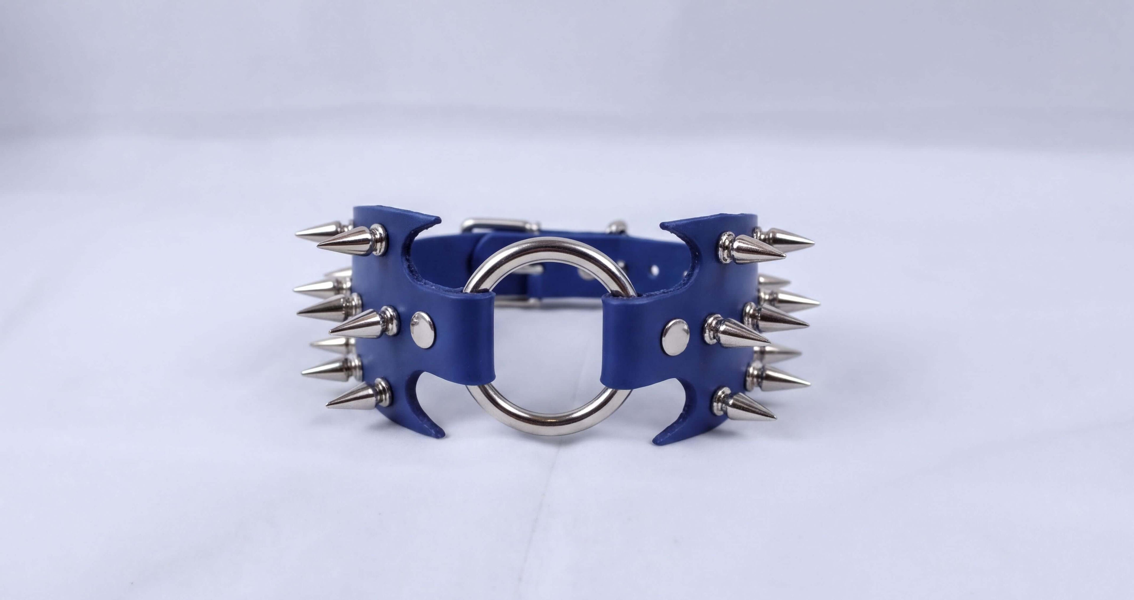 A blue leather bracelet with silver spikes protruding from it.