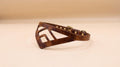 A brown leather collar with a geometric cutout design.