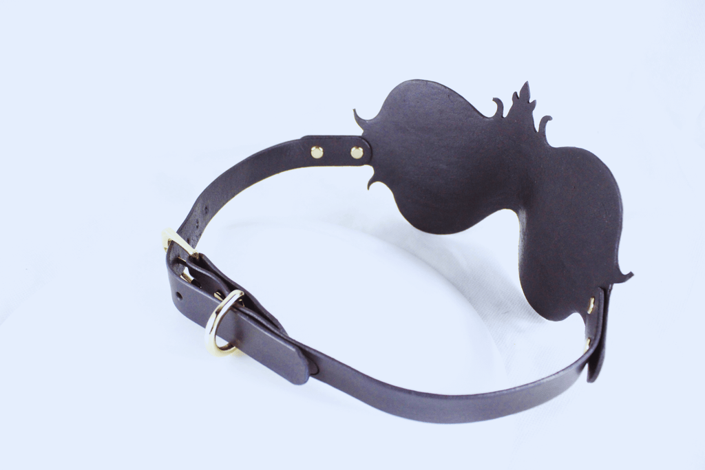 A black leather strap with a decorative design on the end, possibly a headband or accessory.
