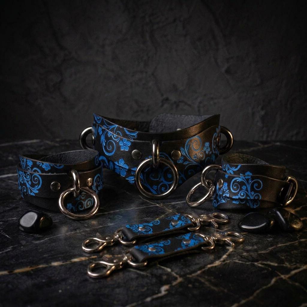 A collection of black leather straps with blue floral designs, arranged on a dark surface.