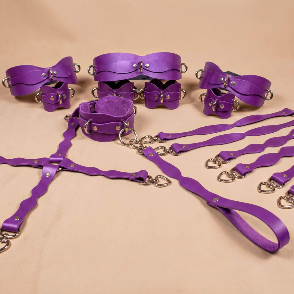 a collection of purple leather straps and buckles arranged on a beige background.