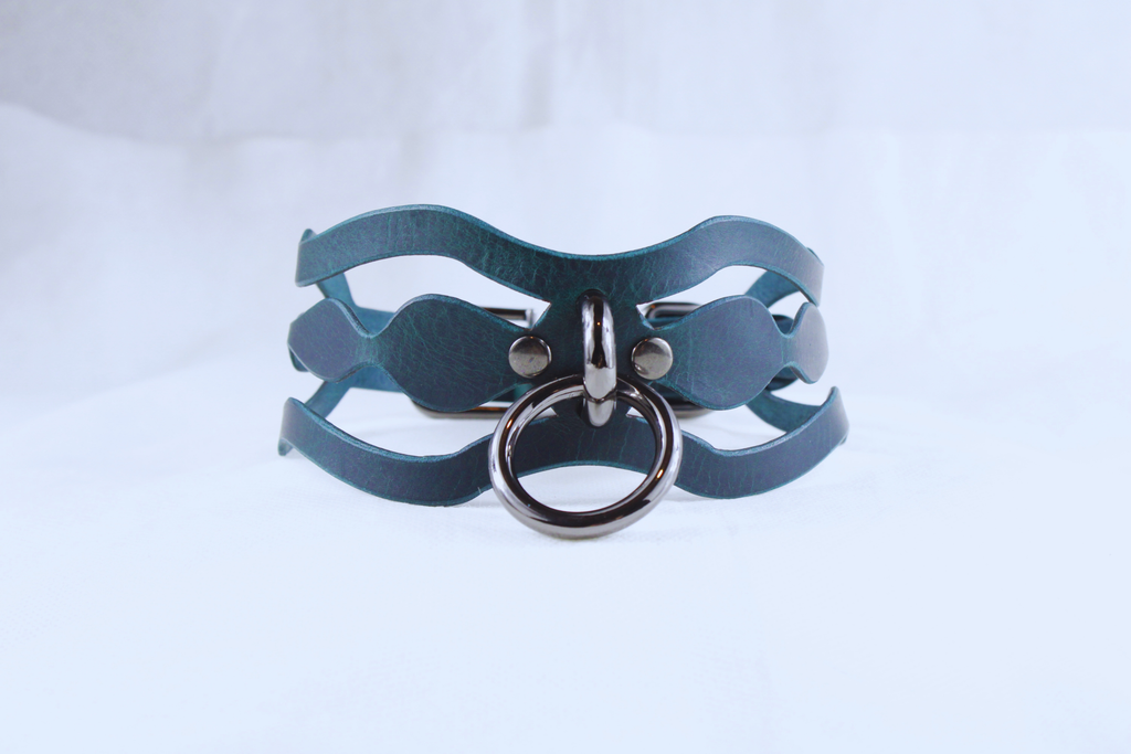 A dark blue leather choker necklace with a metal ring and a metal clasp.