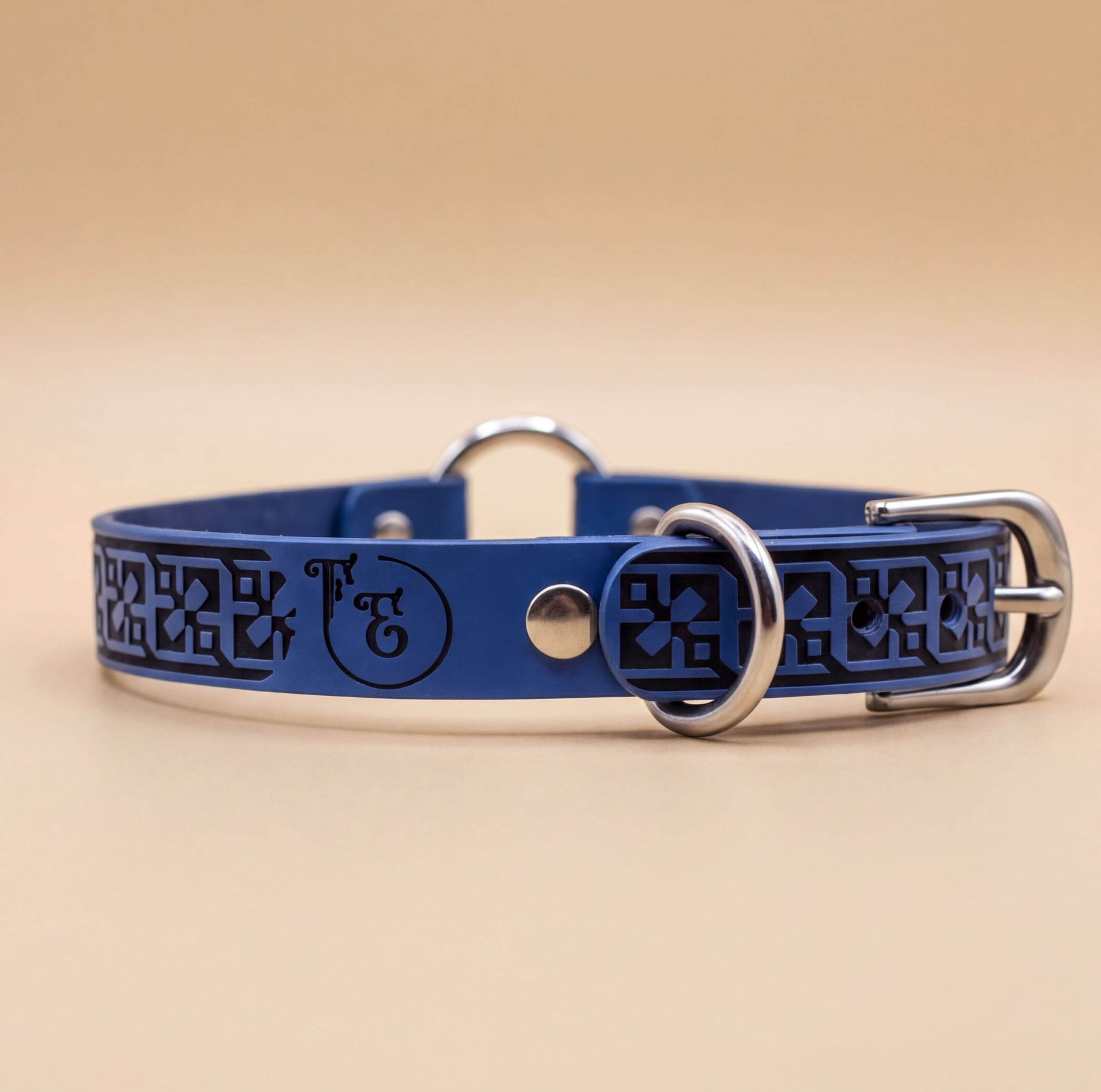 A blue leather dog collar with a metal buckle and a decorative pattern on the surface.