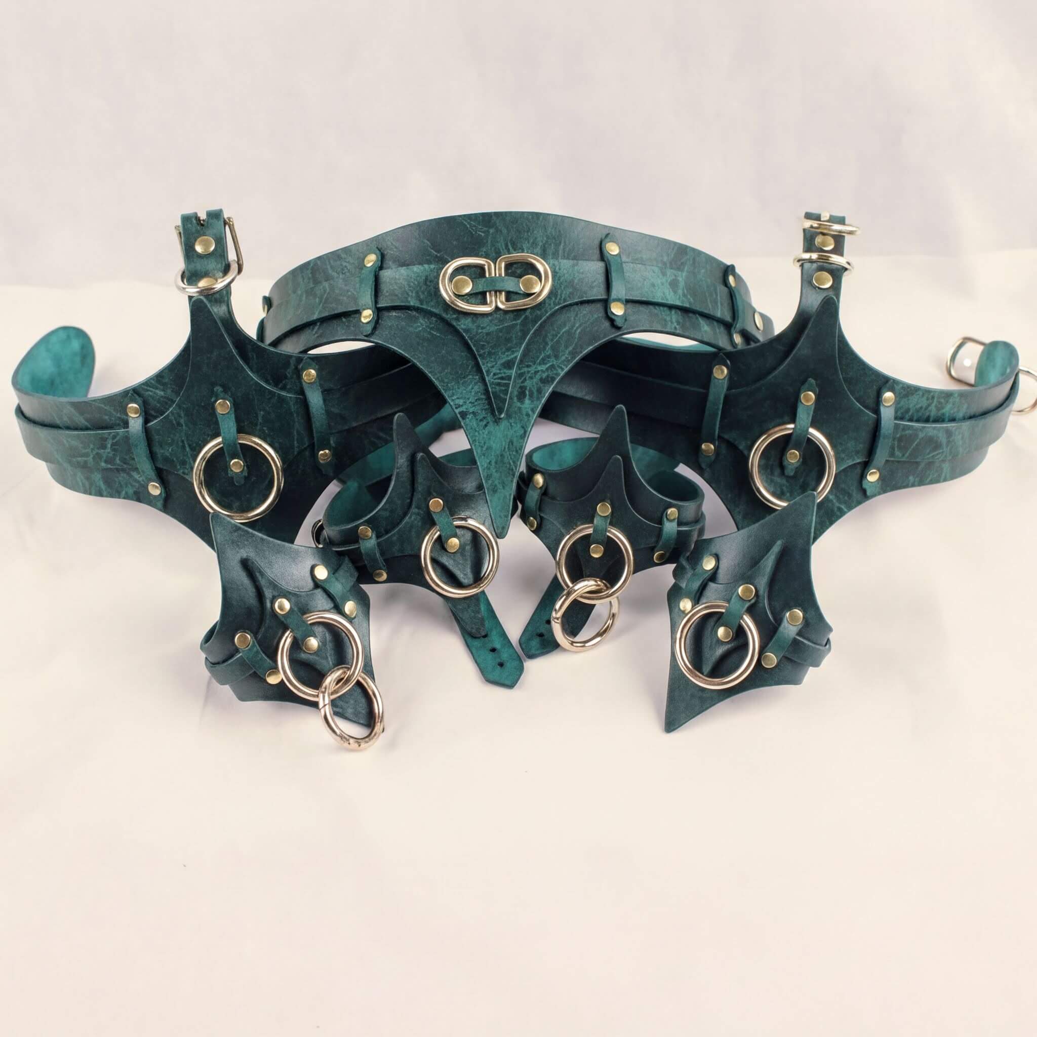 A collection of green leather straps with metal rings and buckles, arranged in a decorative manner.