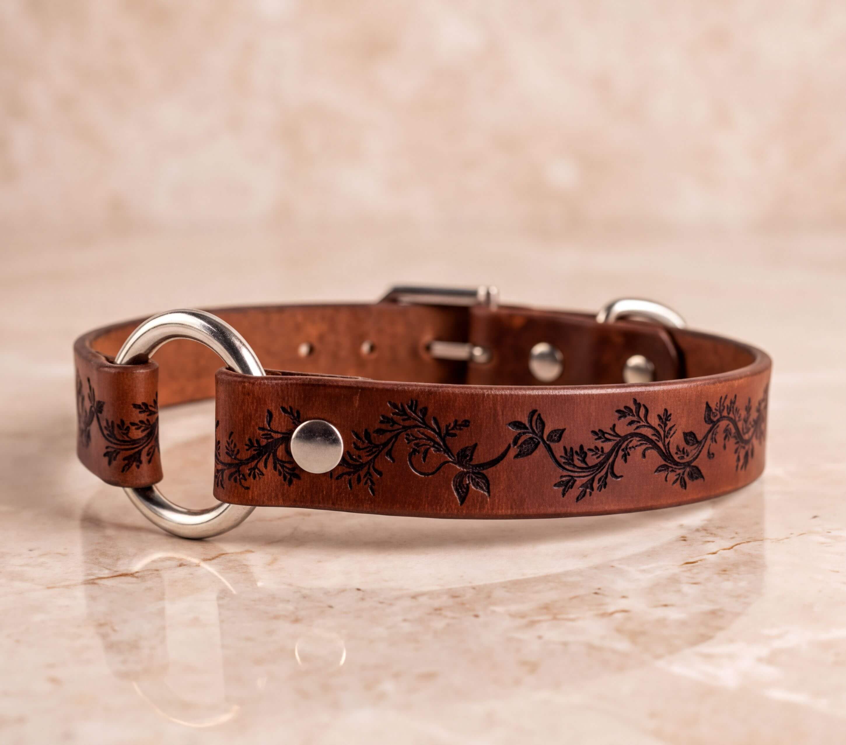 A brown leather dog collar with a decorative floral pattern on the strap.
