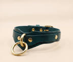 A dark green leather choker collar with a gold ring and buckle.