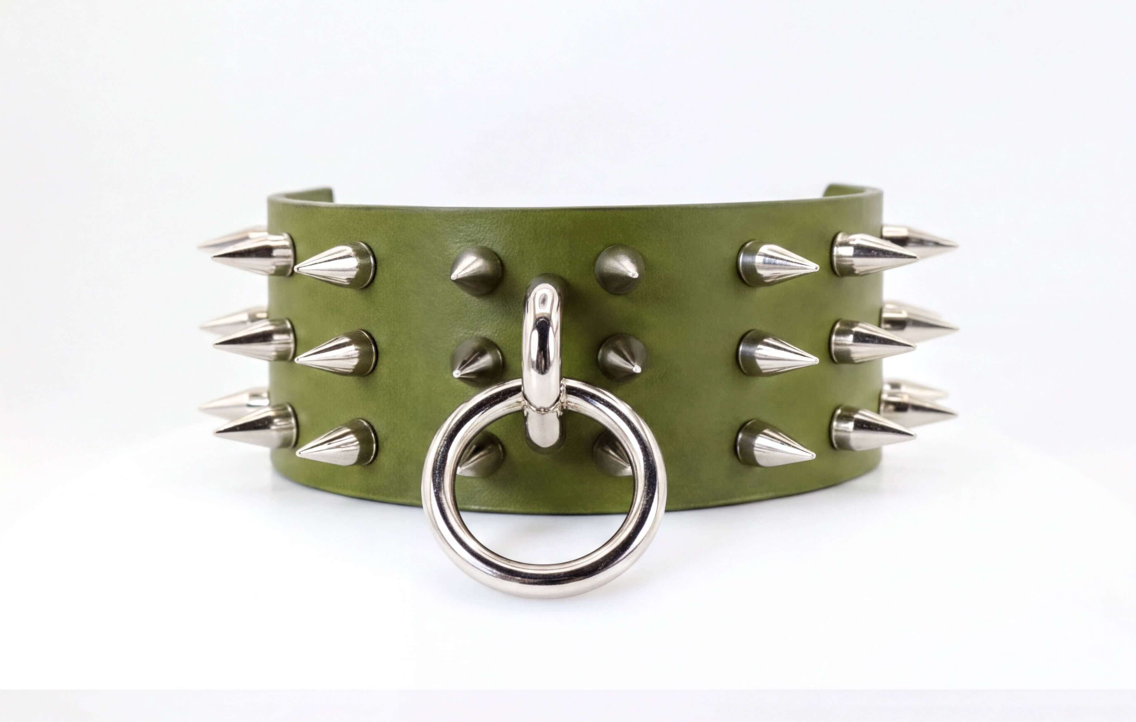 A green leather choker necklace with silver spikes protruding from it.