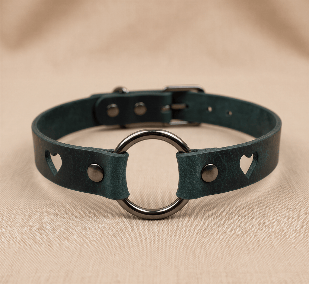 A dark green leather choker necklace with a metal ring and heart-shaped cutouts on the sides.