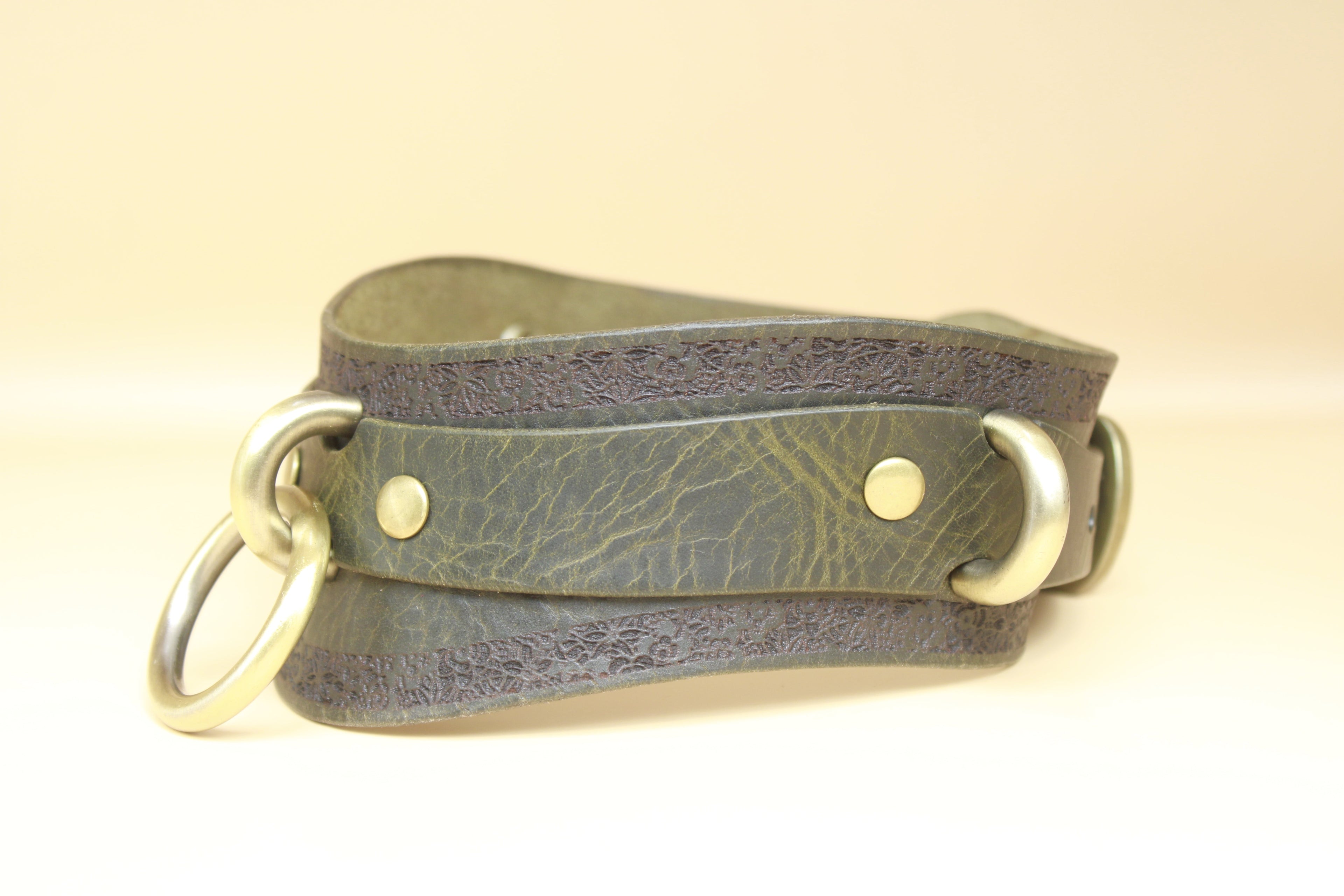 A leather strap with metal rings and buckles, likely used for securing or fastening items.