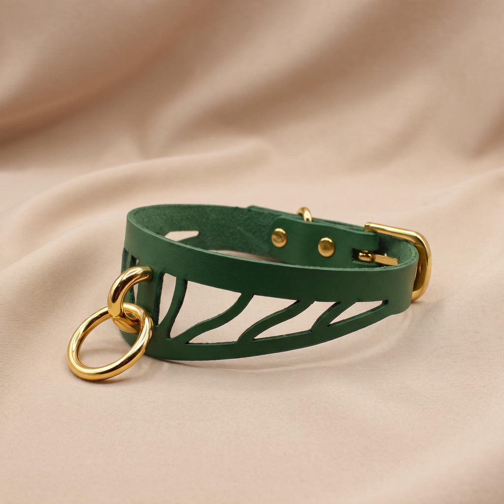 A green leather choker necklace with a gold-colored metal clasp and a zigzag pattern on the front.