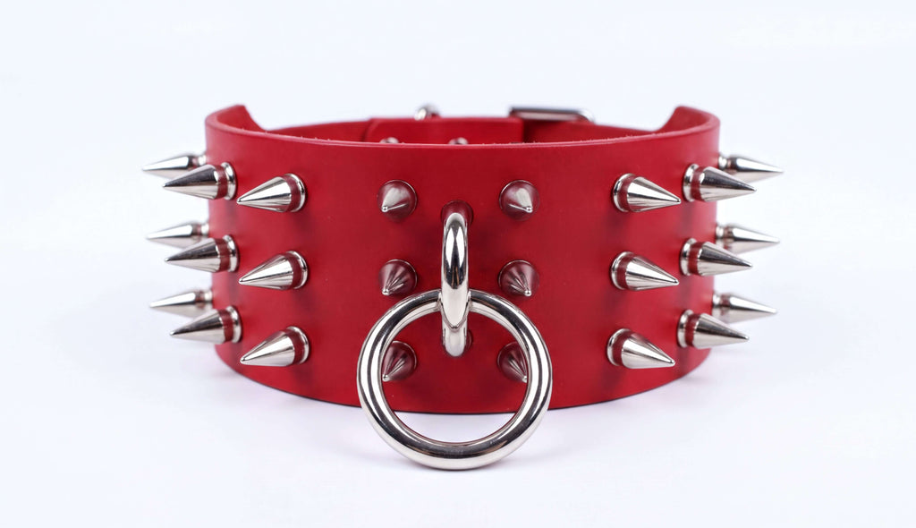 A red leather choker necklace with spikes protruding from it.