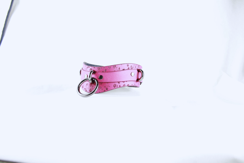 Rose Leather Submissive Collar – pink leather collar with rings on a white background.