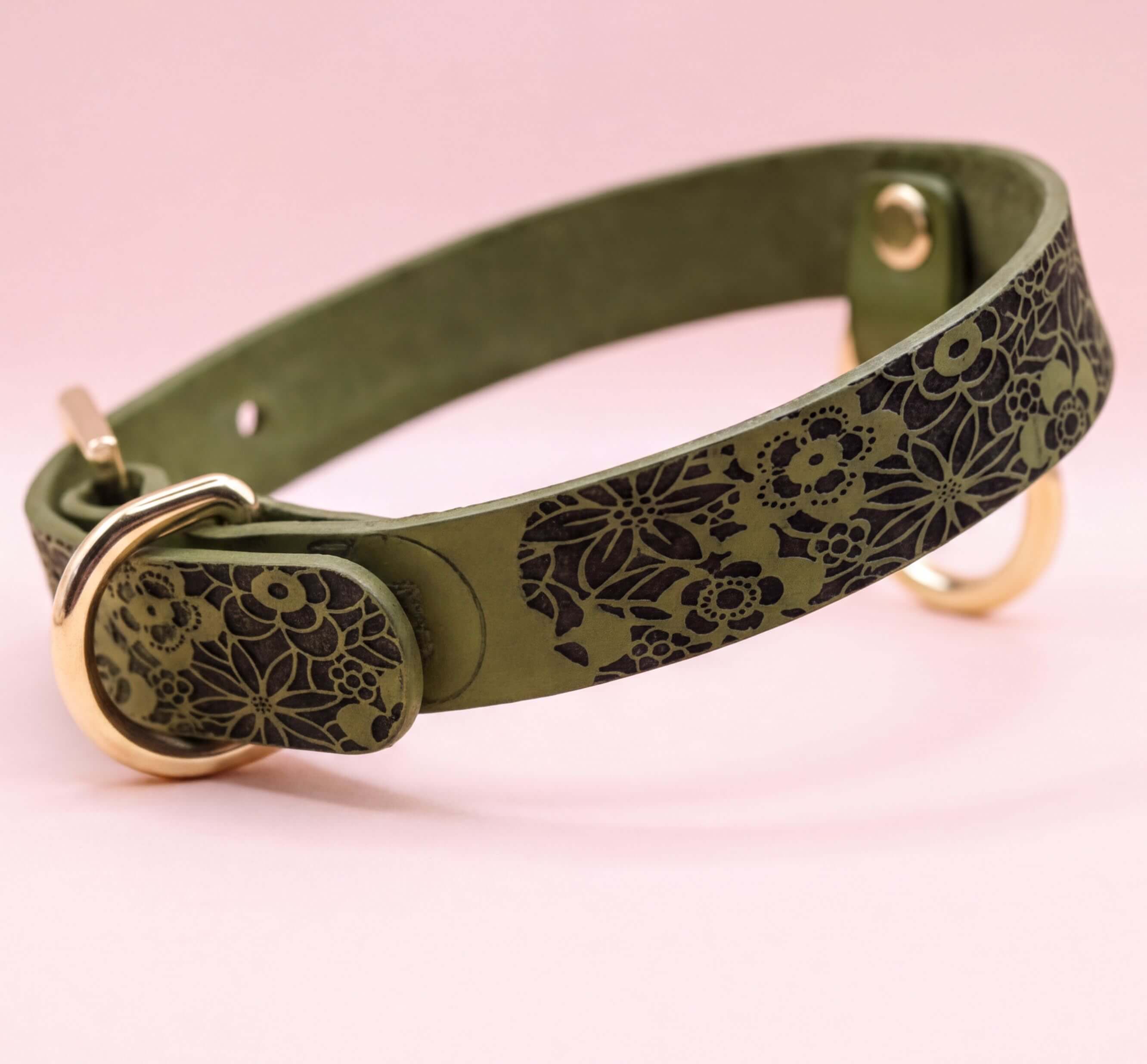 A green leather collar with a floral pattern on it.