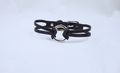 A black leather choker necklace with a silver circular clasp.