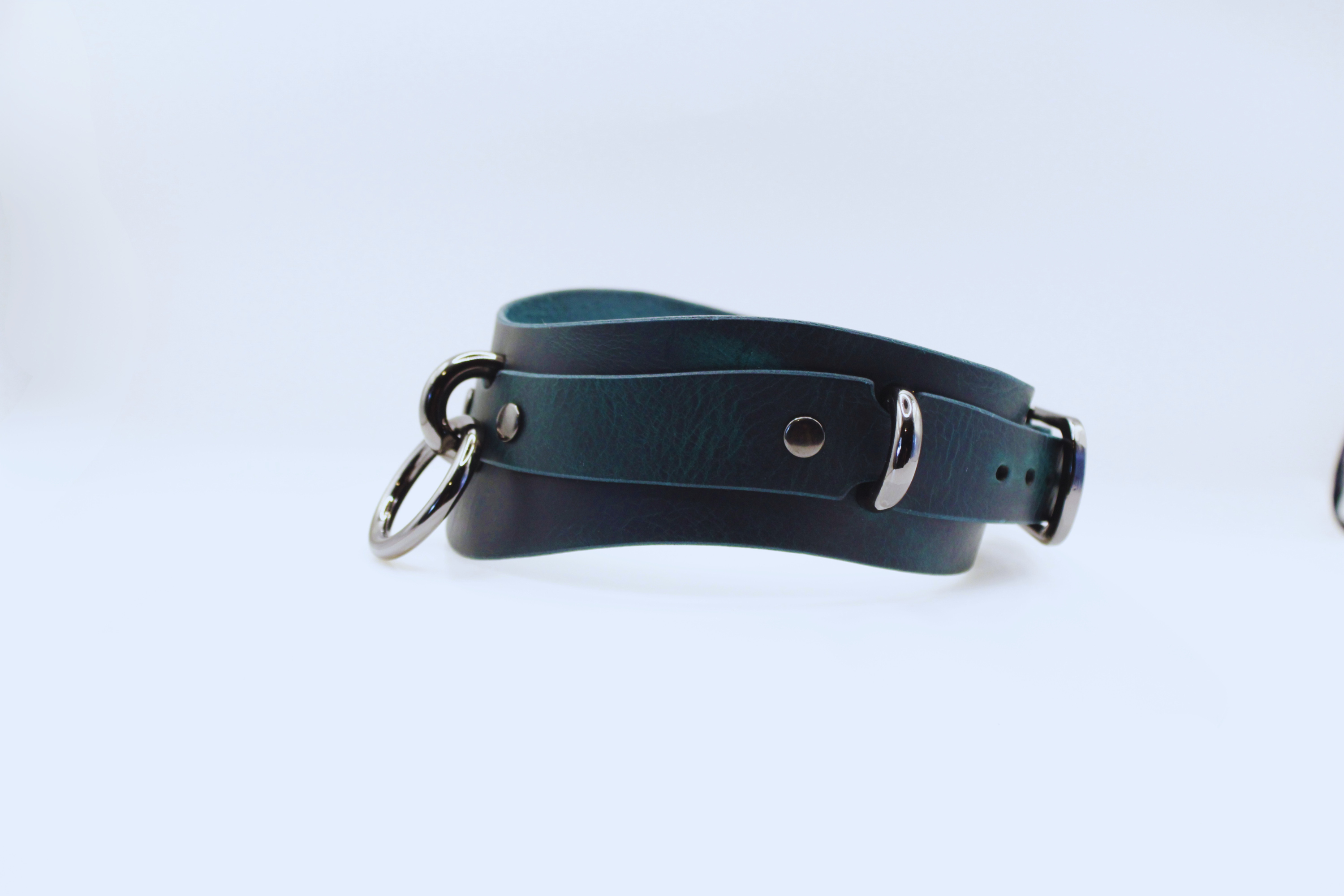 A dark green leather choker necklace with metal buckles and a metal clasp.