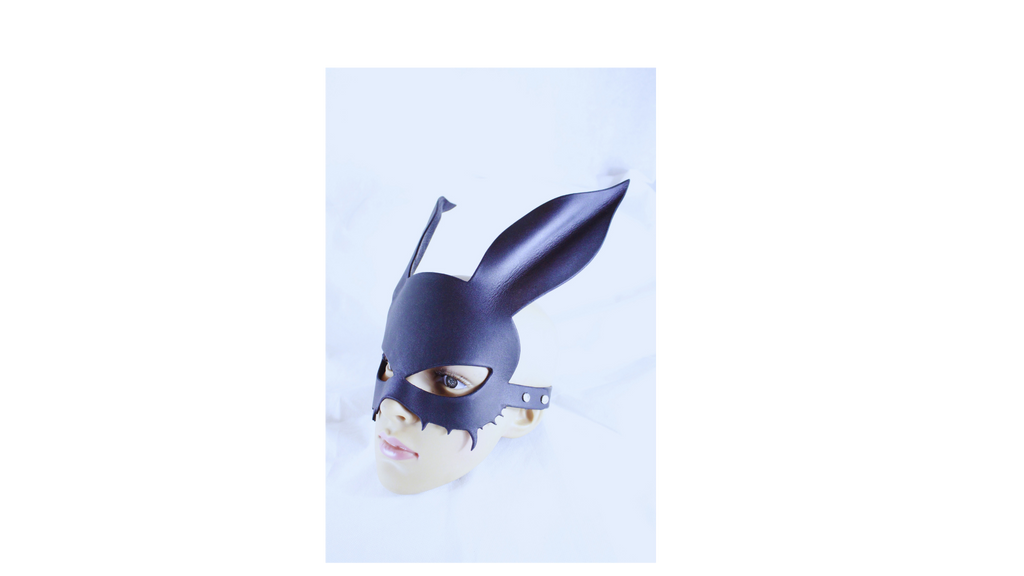 A mannequin head wearing a black mask with large ears, resembling a cat or bunny mask.