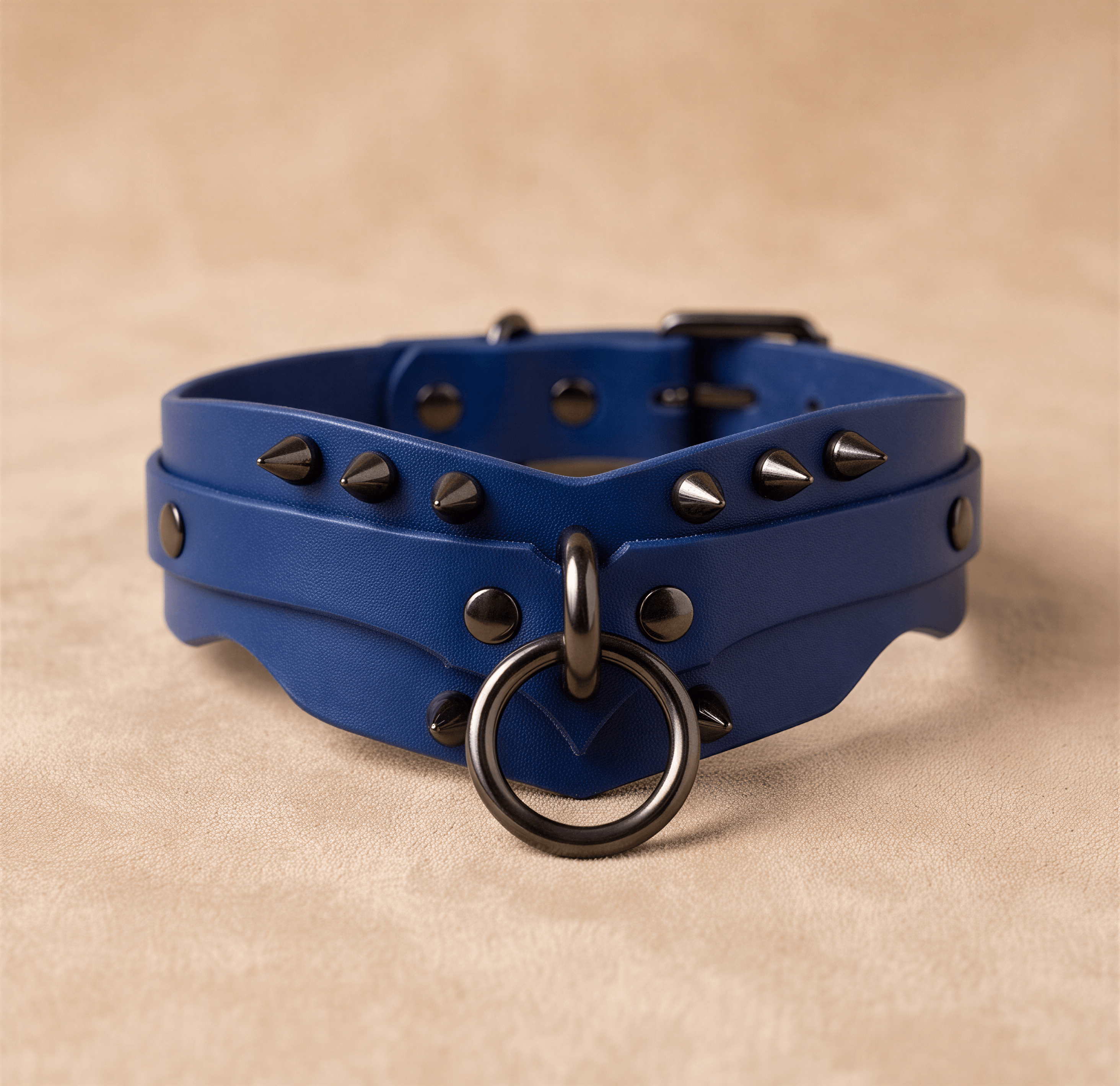 A blue leather choker necklace with spikes and a metal ring on the front.