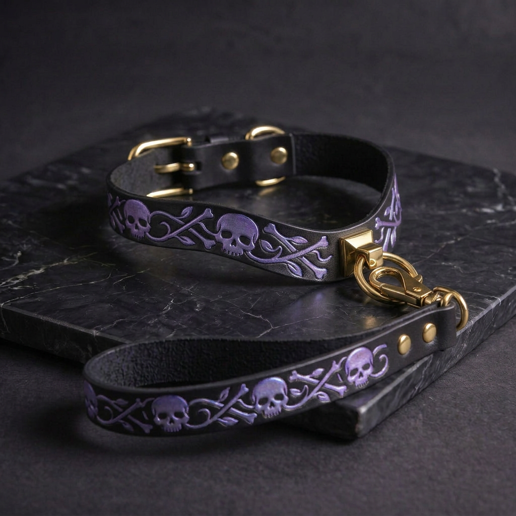 A black leather dog collar with purple skull designs and a gold-colored metal buckle.