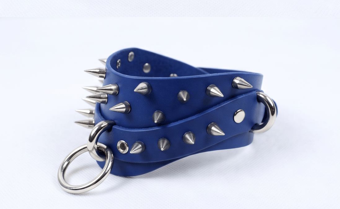 A blue leather choker necklace with silver spikes protruding from it.