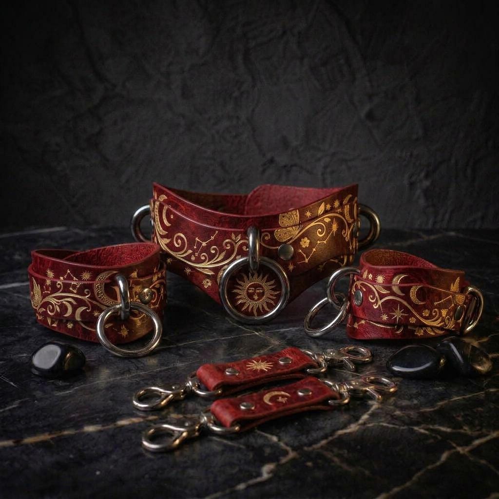 a collection of red leather straps with gold designs, including a sun and moon motif, arranged on a dark surface.