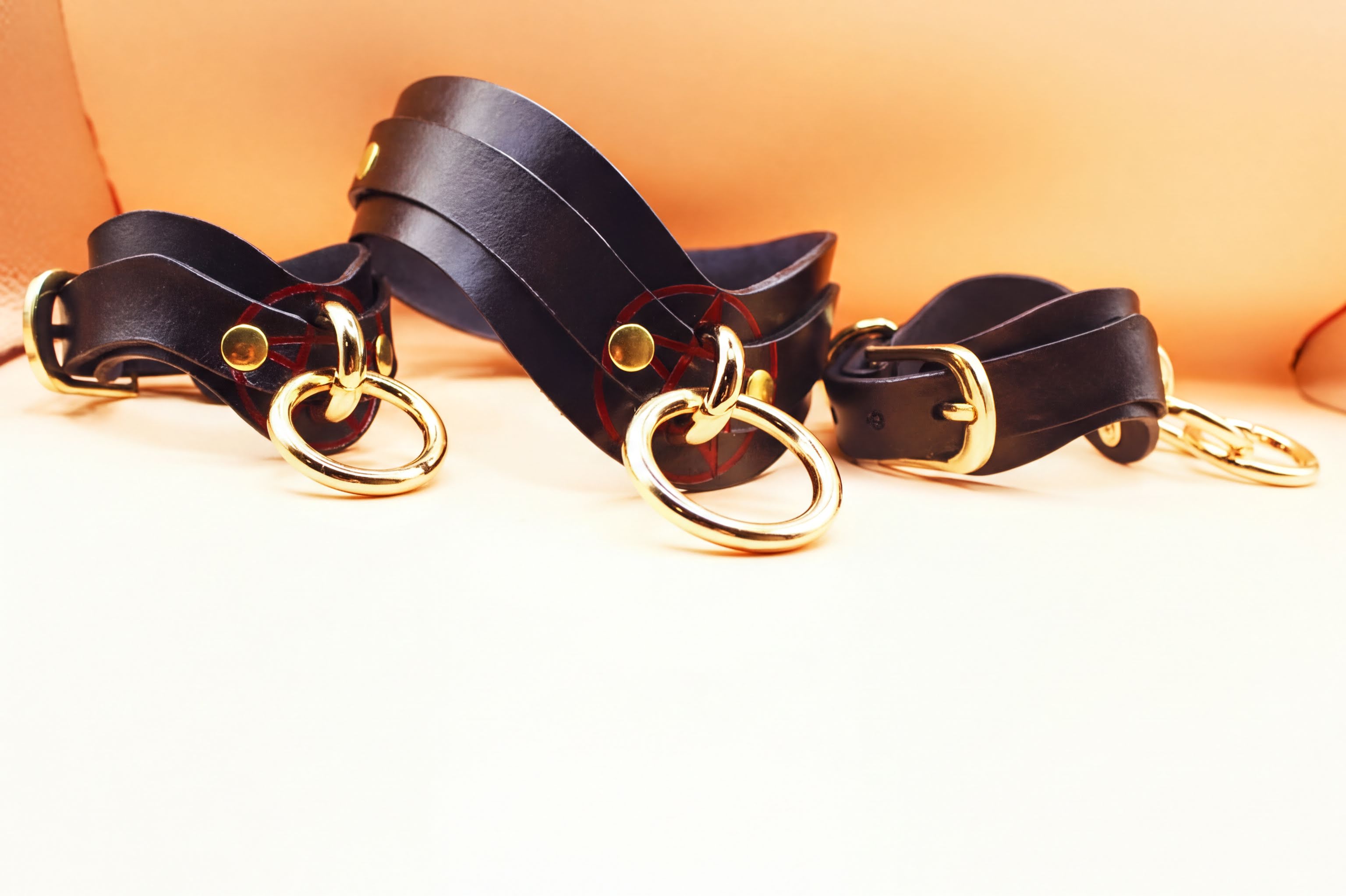 Pentagram BDSM collar set featuring leather straps and gold rings, ideal for bondage and submissive play in erotic lingerie.