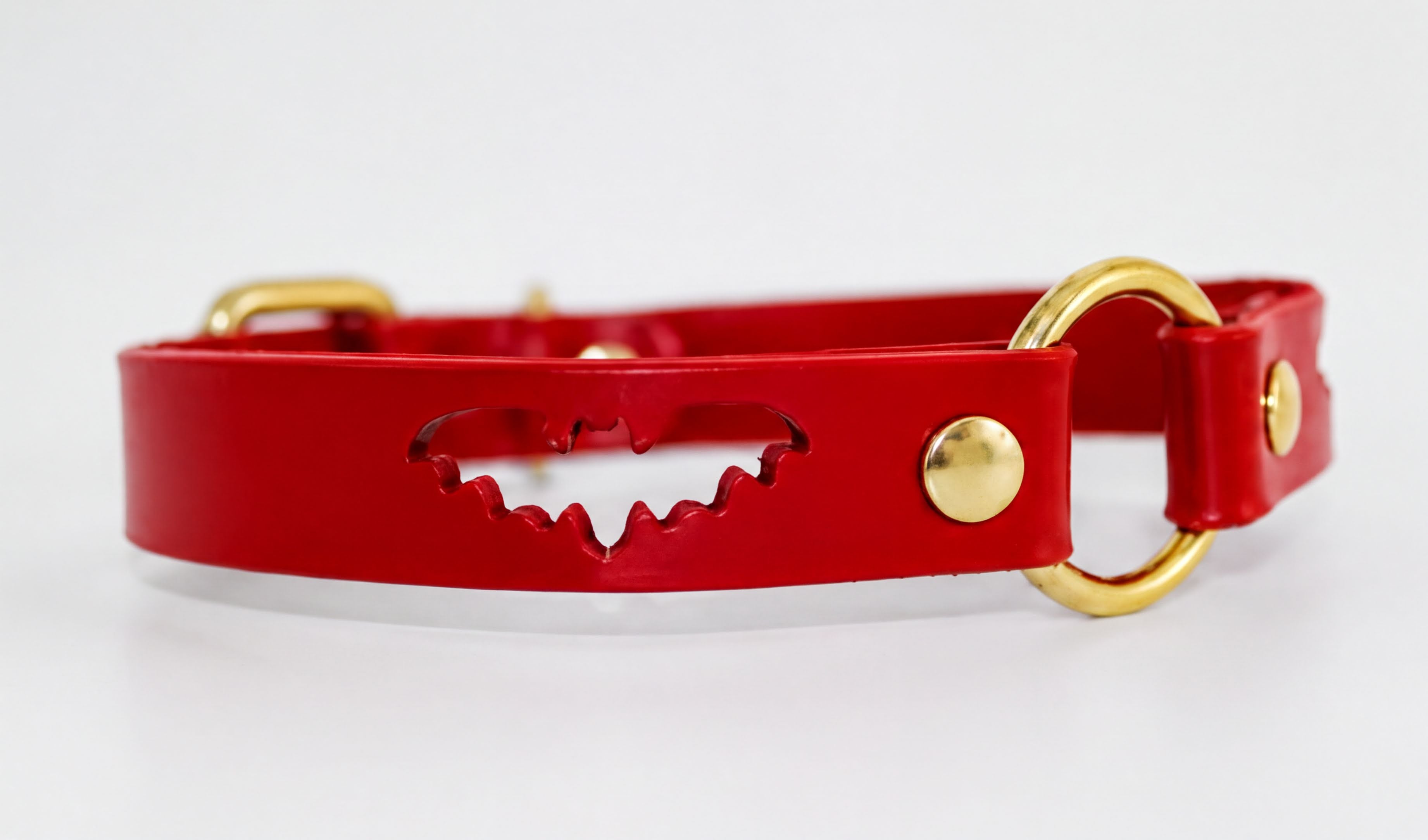 A red leather collar with a bat-shaped cutout in the center.