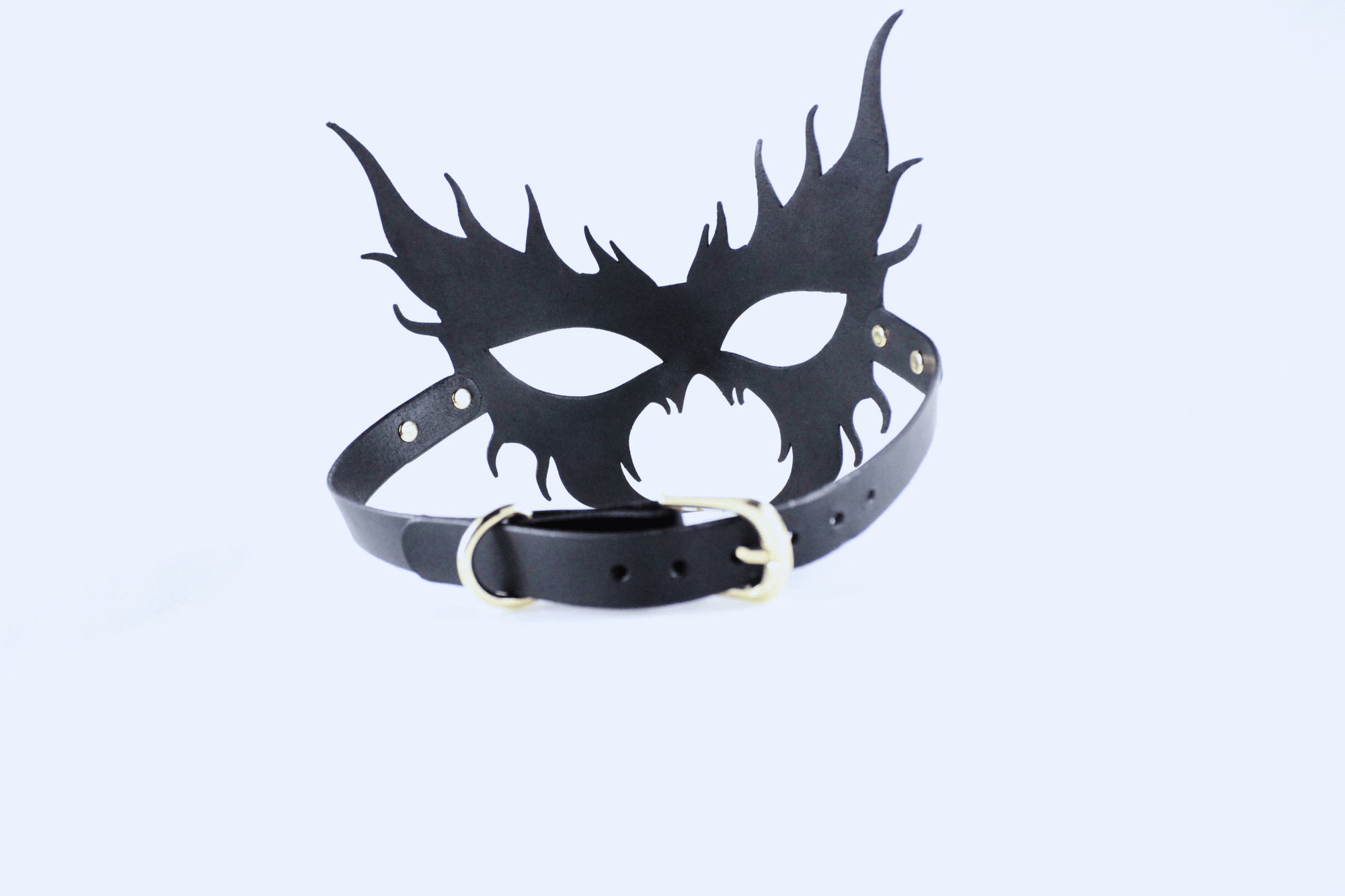 A black mask with sharp, pointed features and a black leather strap.