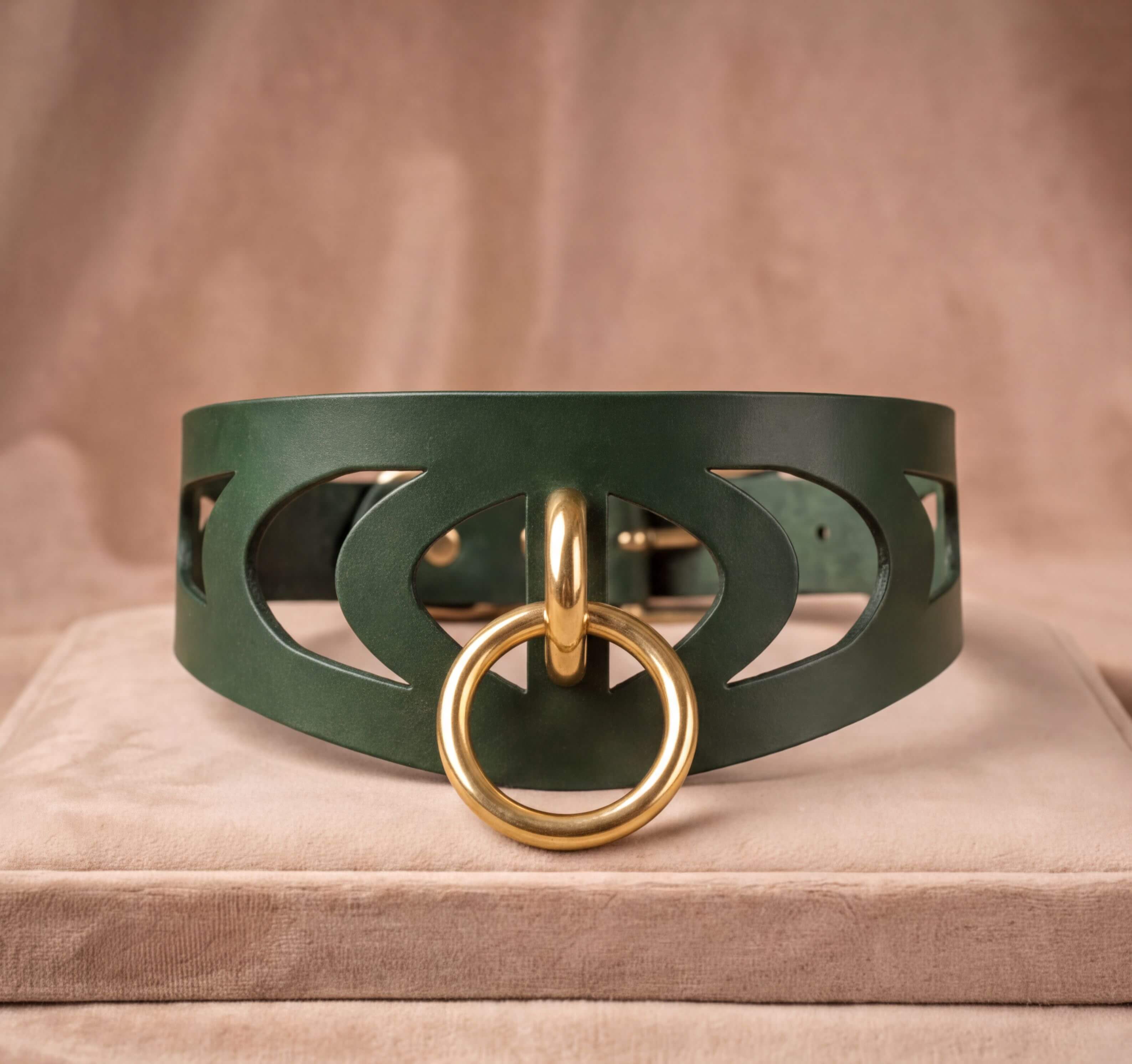 A green leather choker necklace with a gold-colored circular clasp and a cutout design on the front.