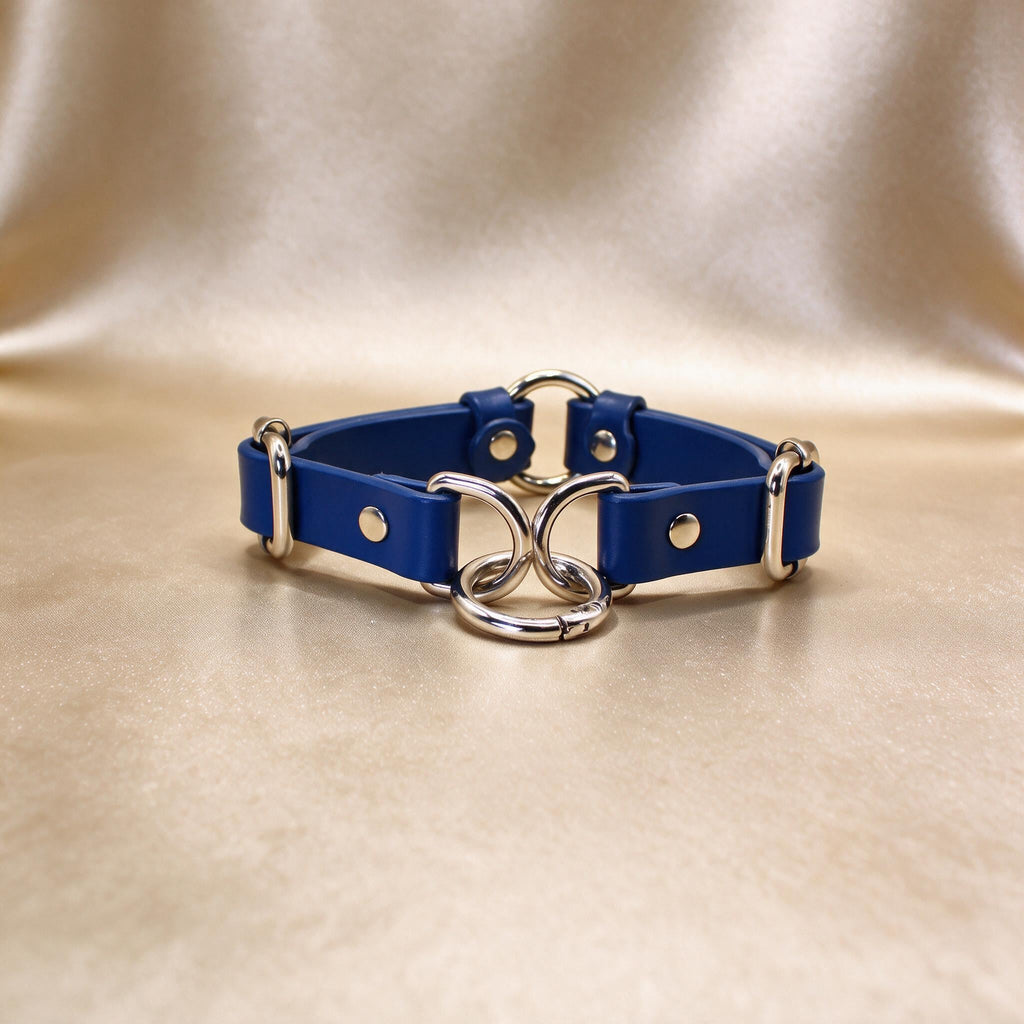 A blue leather choker necklace with metal rings and a metal clasp.