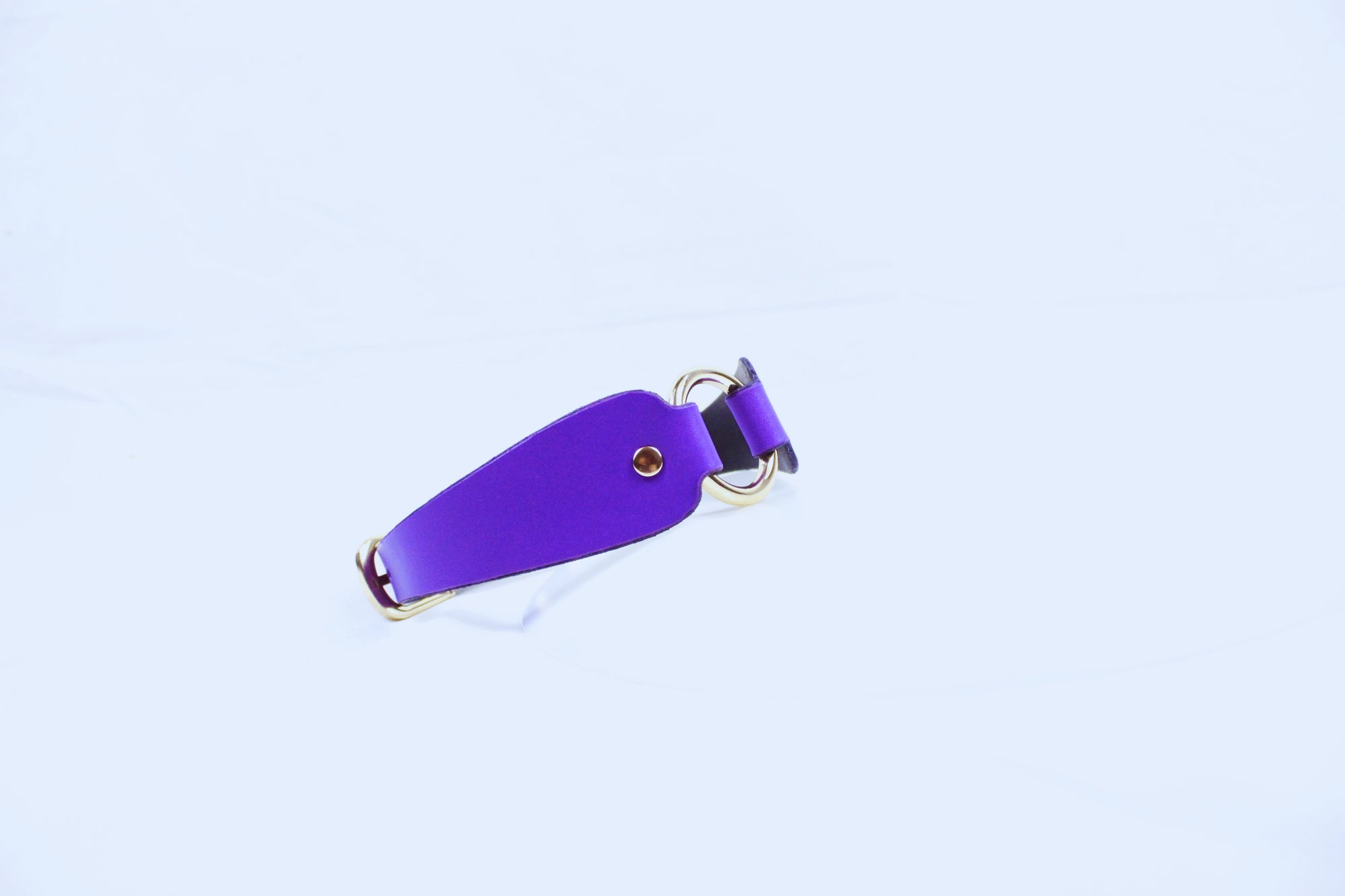 A purple leather strap with a gold buckle is shown against a white background.
