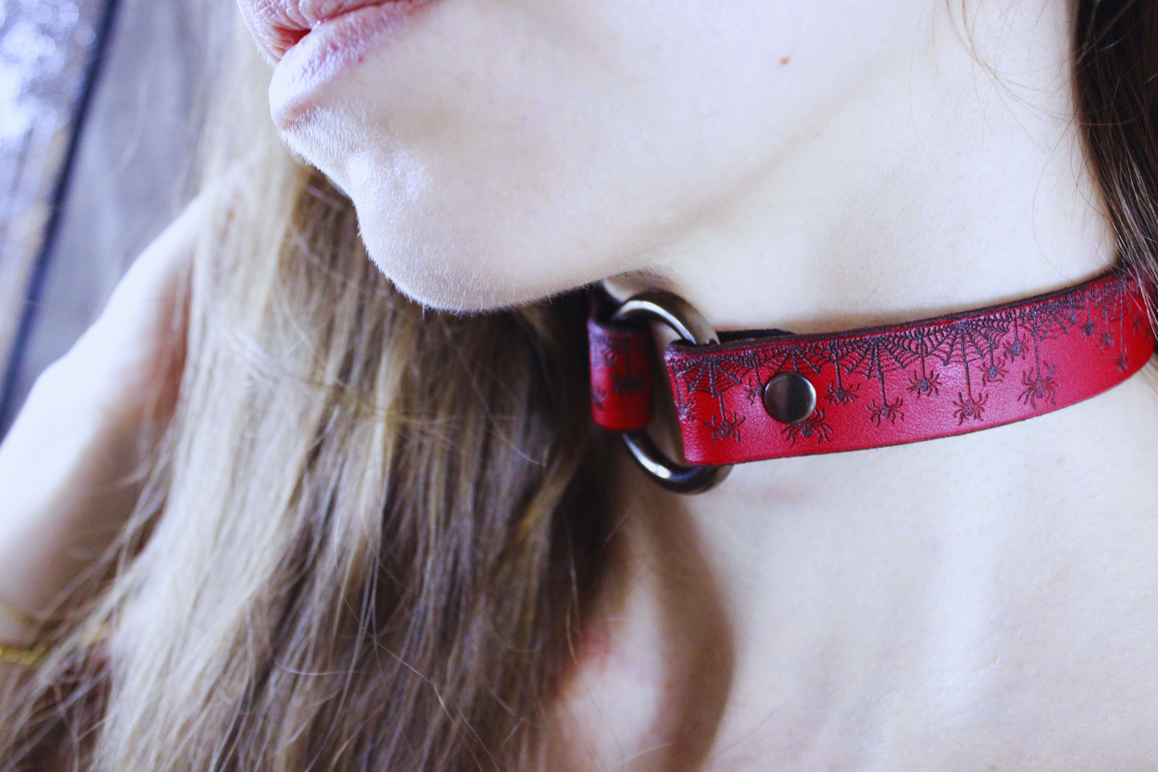 Red Spiderweb Submissive Collar showcased on a model, featuring gothic spiderweb design and striking red leather.