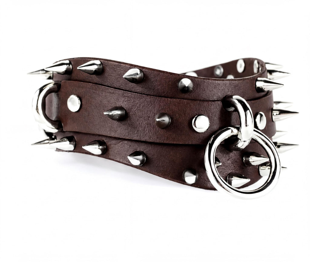 A brown leather belt with silver spikes and a metal ring on it.
