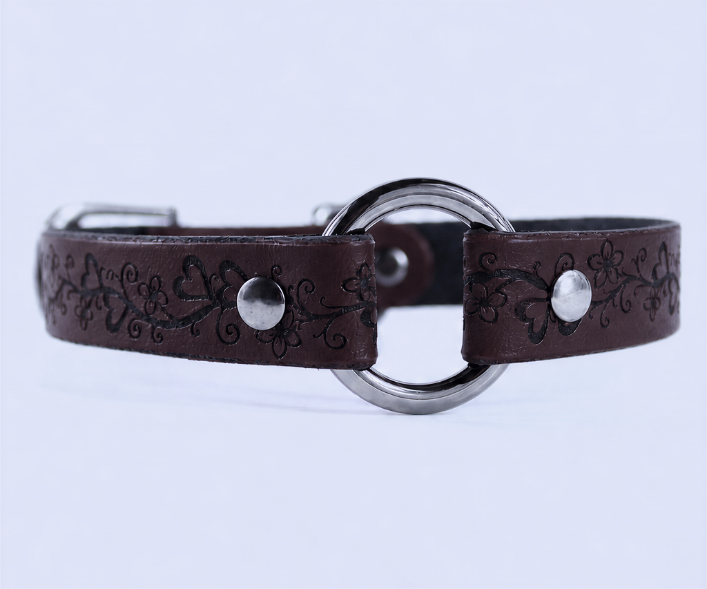 A brown leather collar with a metal ring and floral designs.