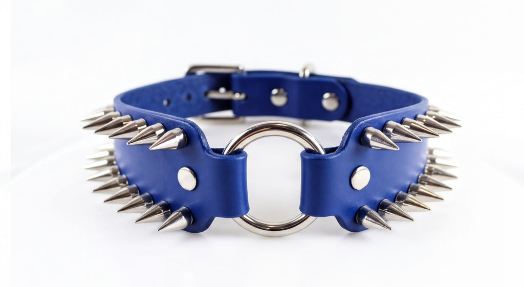 A blue leather collar with spikes protruding from it, featuring a metal ring in the center.