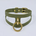 A green choker necklace with a gold-colored metal ring attached to it.