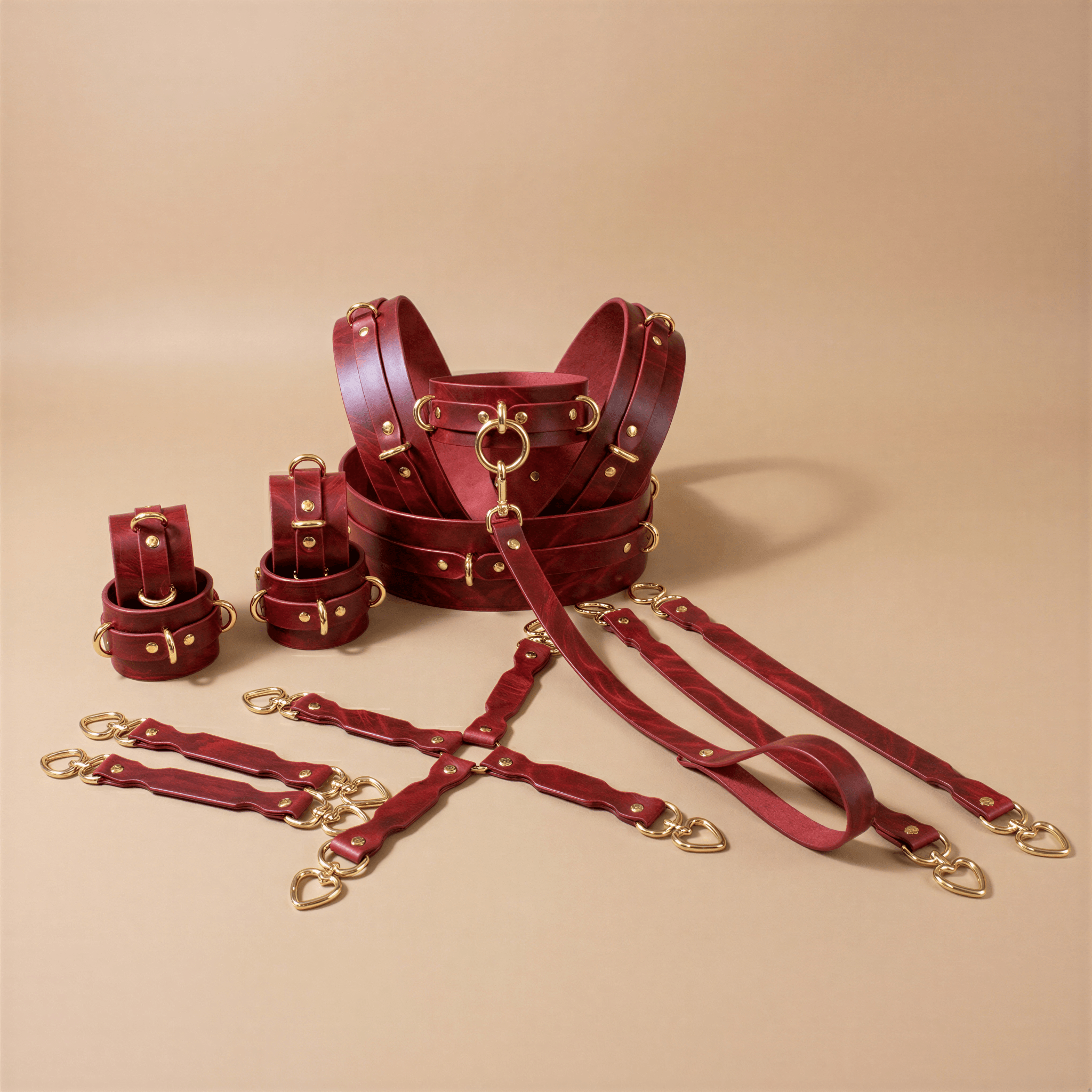a collection of red leather straps and buckles, arranged on a beige background.