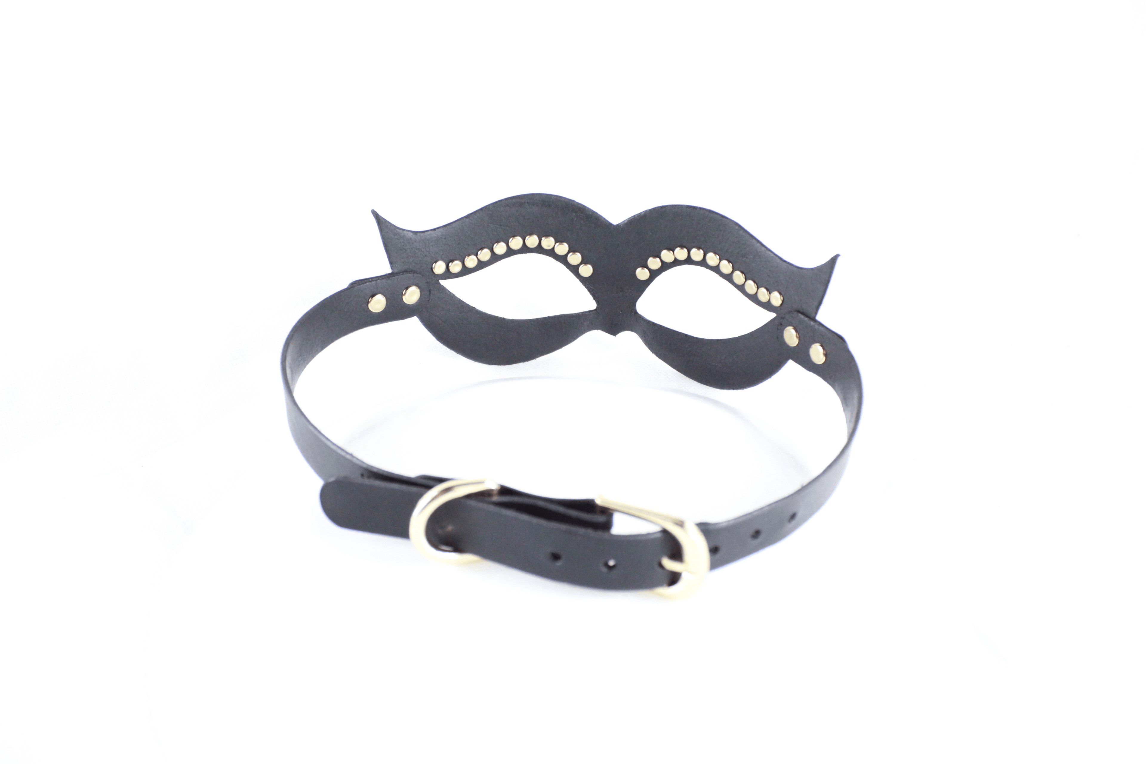 A black leather mask with gold studs on the eyes and a black strap with a gold buckle.