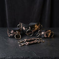 a collection of ornate leather straps and buckles, featuring intricate floral and leaf designs, arranged on a dark surface.