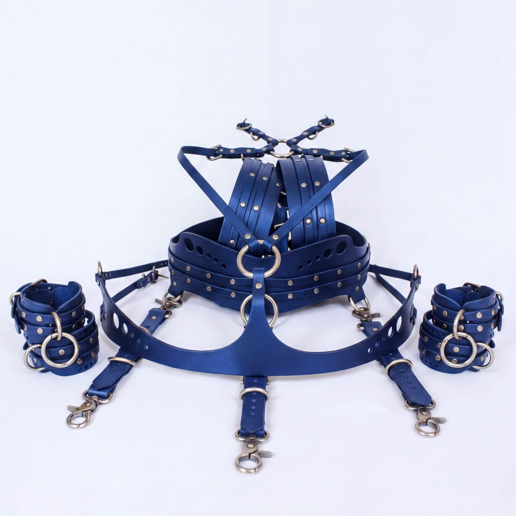 A collection of blue leather straps and buckles, including a headpiece and wrist cuffs, arranged on a white background.