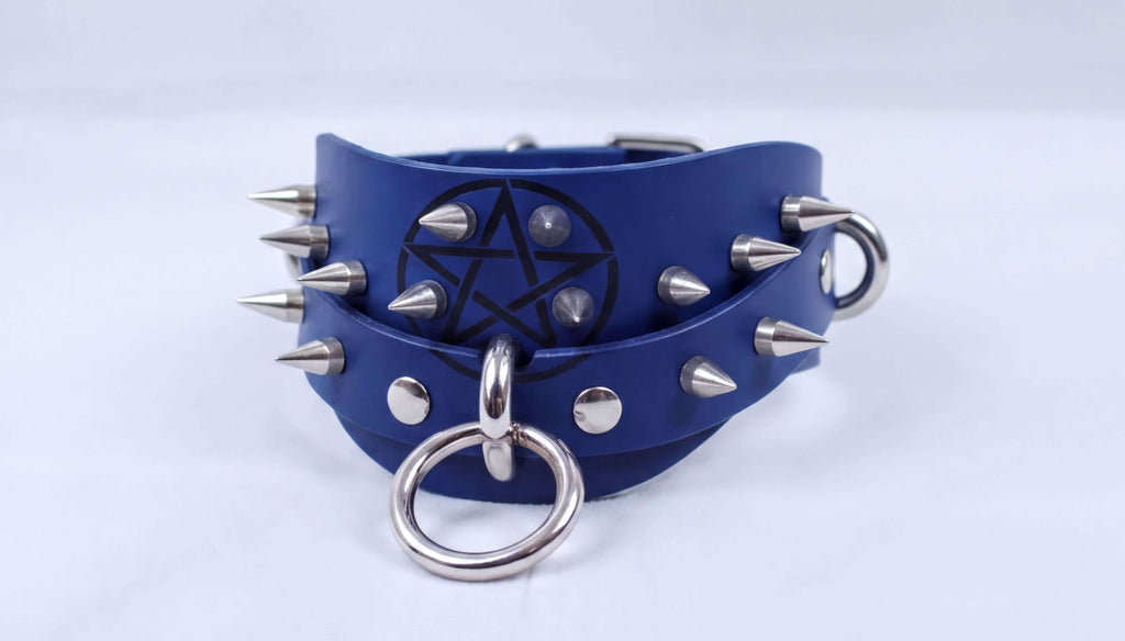 A blue leather collar with silver spikes and a star-shaped emblem is shown in the image.