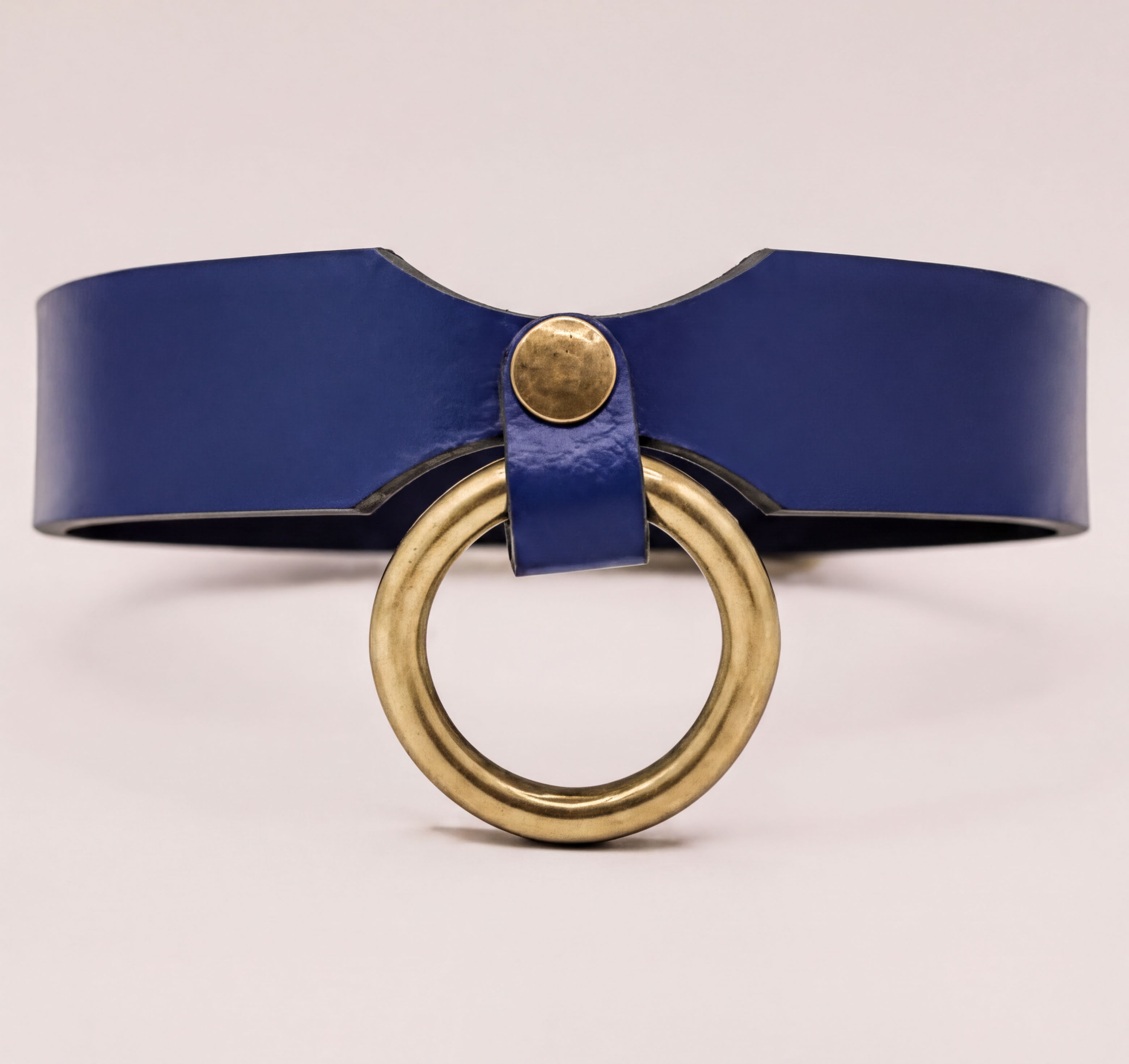 A blue leather choker necklace with a gold-colored circular ring on the front.