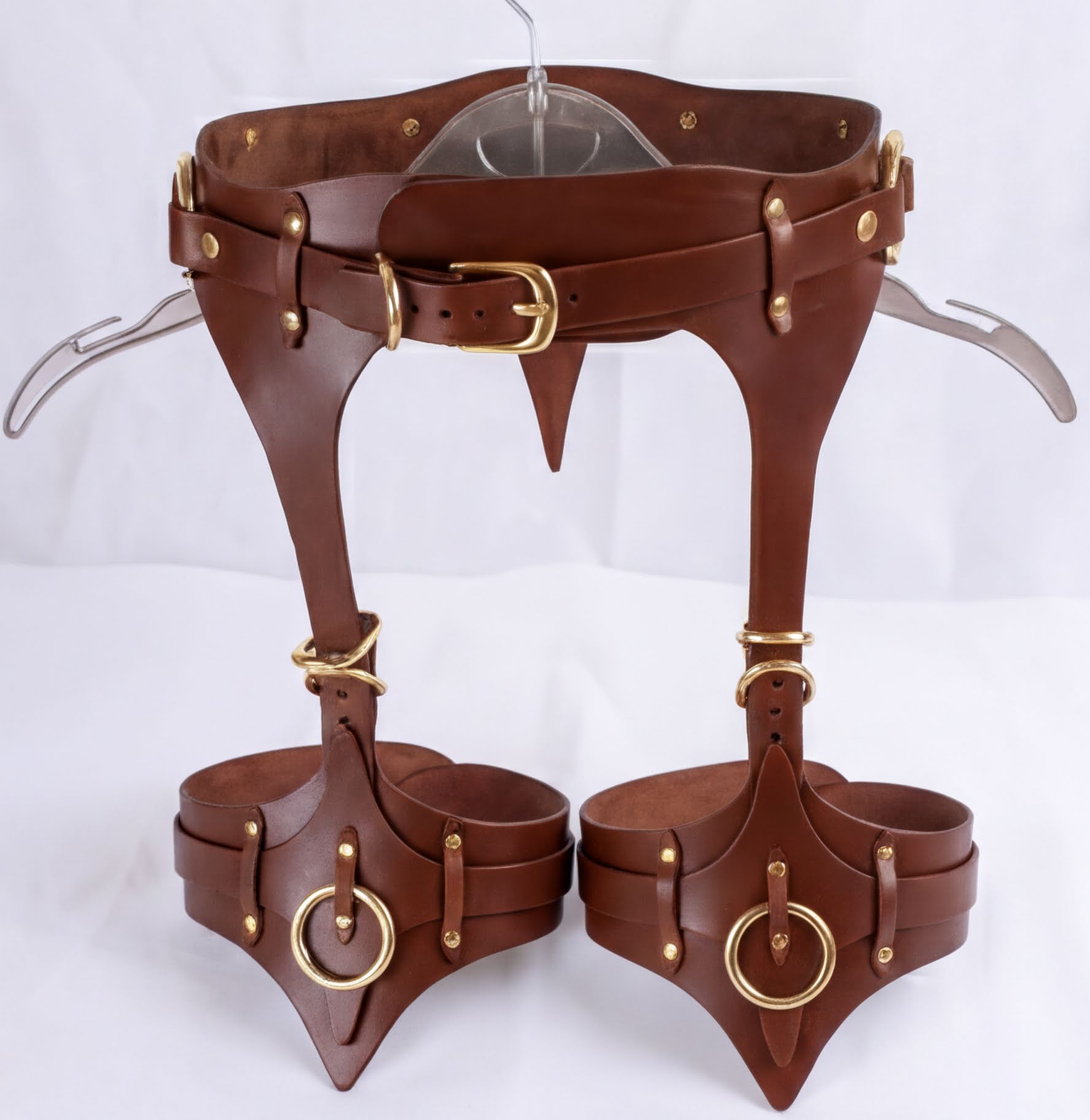 A pair of brown leather straps with gold hardware, designed to be worn as a corset or waist corset.