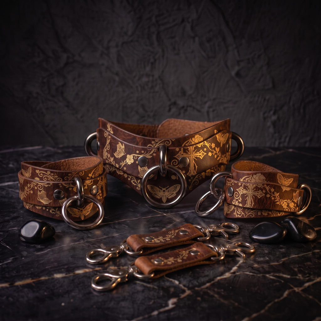 a collection of leather straps and accessories, including a corset-style belt and several leather straps with metal rings and buckles, all arranged on a dark surface.