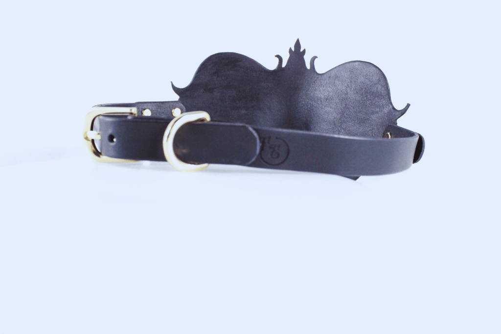 A black leather belt with a decorative metal buckle is shown against a white background.