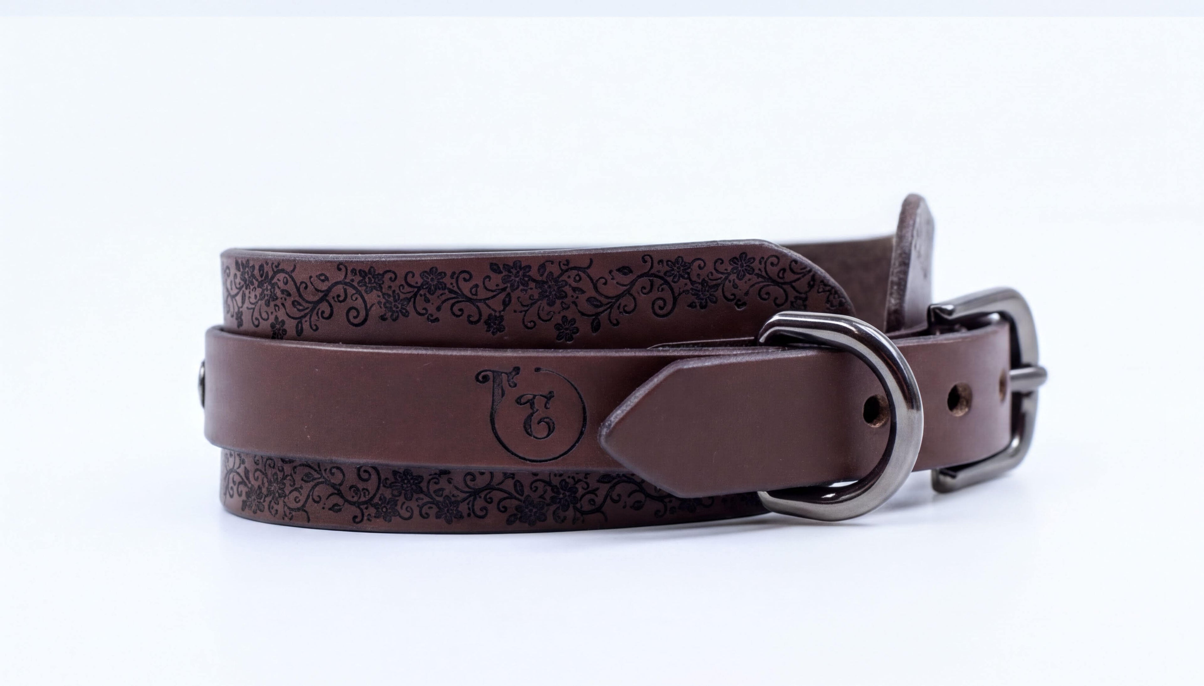 A brown leather belt with a decorative pattern and a metal buckle.