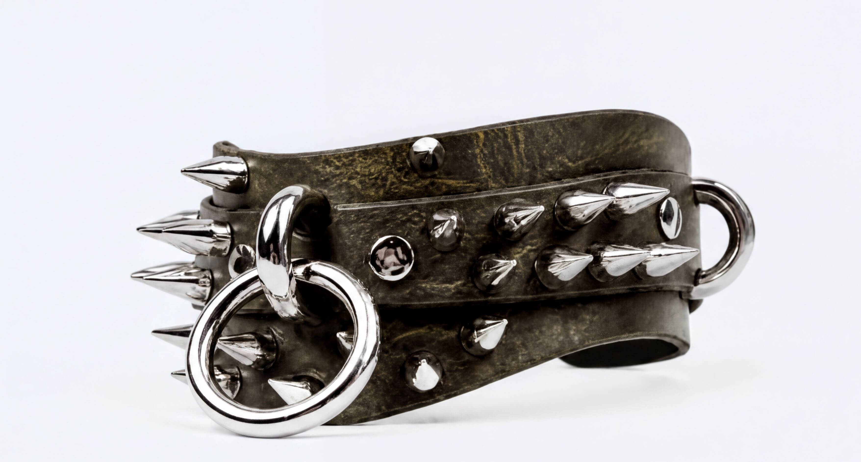 A close-up image of a leather bracelet with spikes and metal rings, creating a bold and edgy appearance.