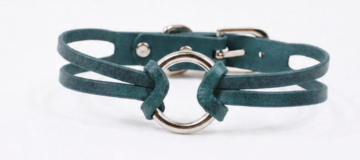 A green leather choker necklace with a silver metal ring in the center.